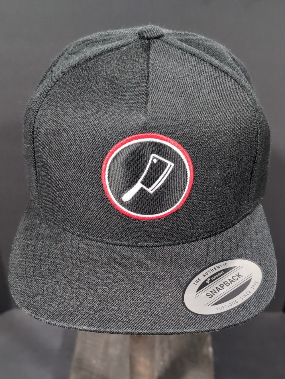 The Classics,Yupoong Flat Bill Snapback Hat Features A Cleaver Logo.